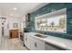 Modern kitchen with blue tile backsplash, white countertops, and stainless steel appliances at 1814 W Thomas Rd, Phoenix, AZ 85015