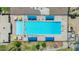 Top-down aerial of a sparkling pool with umbrellas and surrounding seating, perfect for relaxation and fun at 1814 W Thomas Rd, Phoenix, AZ 85015