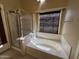 Bright bathroom featuring a soaking tub and separate glass-enclosed shower at 18899 N 77Th Ave, Glendale, AZ 85308