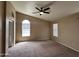 Large bedroom featuring a ceiling fan, neutral walls, soft carpet, and archway window at 18899 N 77Th Ave, Glendale, AZ 85308