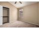 Neutral bedroom featuring tan carpet, ceiling fan, and a standard closet at 18899 N 77Th Ave, Glendale, AZ 85308