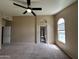 Large bedroom featuring a ceiling fan, neutral walls, soft carpet, and arched doorway at 18899 N 77Th Ave, Glendale, AZ 85308