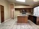 Well-lit kitchen features an island, plenty of cabinets, granite countertops, and tile flooring at 18899 N 77Th Ave, Glendale, AZ 85308