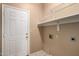 Laundry room featuring white walls, ceramic tile floor, door and shelving at 18899 N 77Th Ave, Glendale, AZ 85308