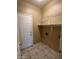 This laundry room features a tile floor, shelving, a door, and a tan wall at 18899 N 77Th Ave, Glendale, AZ 85308