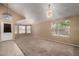 Open living room with high ceiling, carpet, lots of windows, and decorative chandelier at 18899 N 77Th Ave, Glendale, AZ 85308