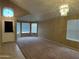 Bright living room with neutral walls, soft carpet, modern light fixture, and archway views at 18899 N 77Th Ave, Glendale, AZ 85308