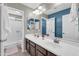 Bathroom featuring dual sinks, a large mirror, and a walk-in shower with glass doors at 2016 S 102Nd Ln, Tolleson, AZ 85353