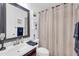 Stylish bathroom with modern fixtures, decorative mirror, and elegant shower curtain at 2016 S 102Nd Ln, Tolleson, AZ 85353