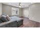 Cozy bonus room with hardwood floors, a sectional sofa, and a window with plantation shutters at 2016 S 102Nd Ln, Tolleson, AZ 85353