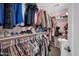 Walk-in closet with pink walls, clothing racks, and shelves displaying shoes and storage boxes at 2016 S 102Nd Ln, Tolleson, AZ 85353