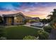 Gorgeous backyard featuring a covered patio, green lawn, pool, and spa create an outdoor oasis at 2094 E Aris Dr, Gilbert, AZ 85298