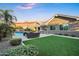 Beautiful backyard features a built-in kitchen, green grass, and an outdoor swimming pool at 2094 E Aris Dr, Gilbert, AZ 85298