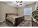Comfortable bedroom featuring a large bed, ceiling fan, and a view to the outside at 2094 E Aris Dr, Gilbert, AZ 85298