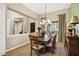 Elegant dining room boasting a coffered ceiling, stylish light fixture, and beautiful wood floors at 2094 E Aris Dr, Gilbert, AZ 85298