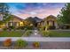 Stunning front exterior with stone accents, lush landscaping, and an inviting walkway at dusk at 2094 E Aris Dr, Gilbert, AZ 85298
