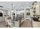 Open kitchen with island with seating, stainless steel appliances, granite counters, and view to the living room at 2094 E Aris Dr, Gilbert, AZ 85298