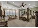 Spacious main bedroom with a four-poster bed, sitting area, elegant lighting, and neutral color palette at 2094 E Aris Dr, Gilbert, AZ 85298