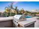 Inviting outdoor kitchen and BBQ area with grill, pool, and desert landscaping create a backyard oasis at 2094 E Aris Dr, Gilbert, AZ 85298