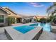 Gorgeous backyard featuring a sparkling pool with a built-in spa, outdoor seating, and lush landscaping at 2094 E Aris Dr, Gilbert, AZ 85298