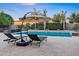 Outdoor living includes a patio with lounge chairs and a cantilever umbrella overlooking the sparkling pool at 2094 E Aris Dr, Gilbert, AZ 85298