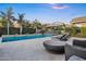 Relaxing backyard with refreshing pool, a tanning shelf, a patio, and beautiful green landscaping at 2094 E Aris Dr, Gilbert, AZ 85298