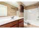Bathroom with dark wood cabinets and hardware, white countertops and a shower tub combo at 2150 E Sunland Ave, Phoenix, AZ 85040