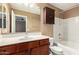 Bathroom featuring a dark wood vanity, framed mirror and a bathtub with shower at 2150 E Sunland Ave, Phoenix, AZ 85040