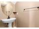 Powder room featuring a pedestal sink, neutral paint, and modern lighting at 2150 E Sunland Ave, Phoenix, AZ 85040