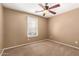 Neutral-toned bedroom with a ceiling fan and a large window for natural light at 2150 E Sunland Ave, Phoenix, AZ 85040