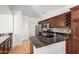 Open kitchen with granite counters, stainless appliances, and hardwood floors at 2150 E Sunland Ave, Phoenix, AZ 85040