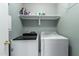 This laundry room offers side by side washer and dryer units, and shelf above at 2150 E Sunland Ave, Phoenix, AZ 85040