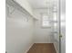 Walk-in closet with carpet flooring, white shelving, and a window for natural light, maximizing storage at 2150 E Sunland Ave, Phoenix, AZ 85040
