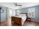 Cozy bedroom featuring a large wooden bed, wood floors, and natural light streaming through the windows at 2185 E Gillcrest Rd, Gilbert, AZ 85298