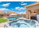 Relaxing backyard with pool, hot tub, and covered patio seating area at 2185 E Gillcrest Rd, Gilbert, AZ 85298