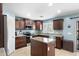 Well-lit kitchen with dark wood cabinets, granite countertops, and stainless steel appliances at 2185 E Gillcrest Rd, Gilbert, AZ 85298