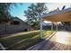 Backyard view with a covered patio, green lawn, block wall and mature shade trees at 2281 E Saratoga St, Gilbert, AZ 85296