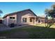 Backyard view with a covered patio, green lawn, block wall and mature shade trees at 2281 E Saratoga St, Gilbert, AZ 85296