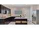 Modern kitchen featuring stainless steel appliances, a kitchen island, and dark cabinets at 24052 W Pima St, Buckeye, AZ 85326