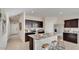 Modern kitchen with granite countertops, dark wood cabinetry, and stainless steel appliances at 24052 W Pima St, Buckeye, AZ 85326