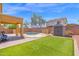 View of the artificial grass backyard with a kidney-shaped pool and covered patio at 2519 W Burgess Ln, Phoenix, AZ 85041
