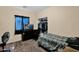 Bedroom featuring carpet, closet, window with blue curtains, and a workspace at 2519 W Burgess Ln, Phoenix, AZ 85041