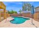 A beautiful kidney-shaped pool surrounded by concrete and a metal fence for safety at 2519 W Burgess Ln, Phoenix, AZ 85041