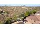 Captivating aerial view showcasing the desert landscape with mountain views surrounding homes with tile roofs and lush greenery at 26703 N 90Th Dr, Peoria, AZ 85383