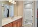 Bathroom featuring a sink with wood cabinets and a shower/tub combo at 26703 N 90Th Dr, Peoria, AZ 85383