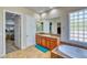Bathroom with walk-in closet, large mirror, soaking tub and natural lighting at 26703 N 90Th Dr, Peoria, AZ 85383