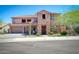Two-story home featuring a three-car garage, stone accents, and a well-manicured front yard at 26703 N 90Th Dr, Peoria, AZ 85383