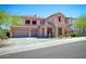 Two-story home featuring a three-car garage, stone accents, and a well-manicured front yard at 26703 N 90Th Dr, Peoria, AZ 85383