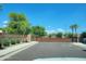 Community entrance featuring a gated entry, desert landscaping and mature trees at 2754 S Apache Dr, Chandler, AZ 85286