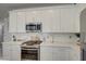 Well-appointed kitchen features white cabinets, stainless steel appliances, and a sleek gas range cooktop at 2754 S Apache Dr, Chandler, AZ 85286